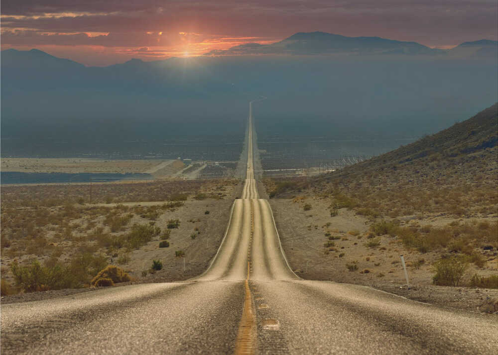 Desert road sunset poster with a long straight road through desert at sunset with mountains