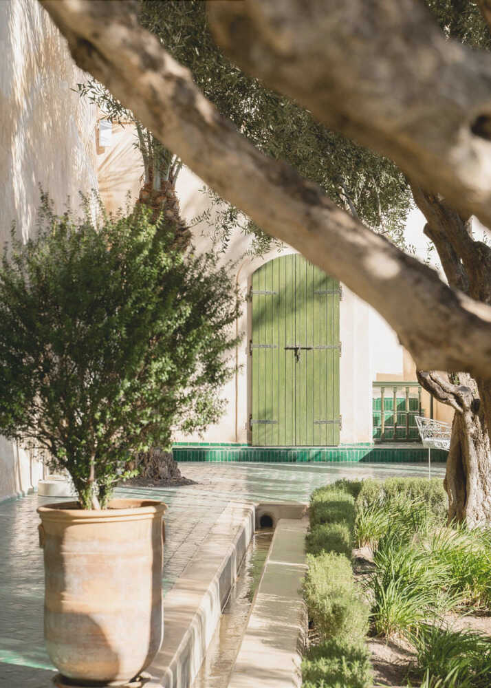 Green door courtyard poster with a green door olive trees and water channel in a courtyard
