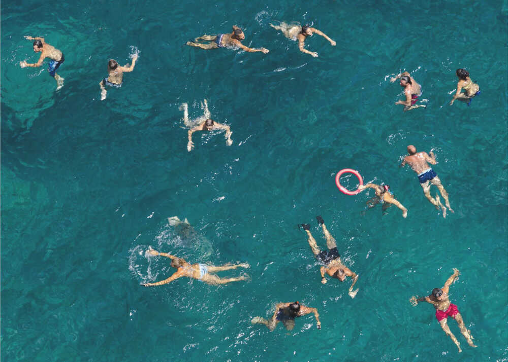 Swimmers aerial poster with an overhead view of people swimming in turquoise water